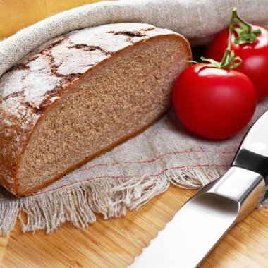 Gri dilimlenmiş ekmek unlu ekmek, domates ve bıçak