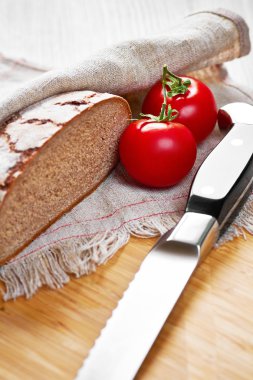 Gri dilimlenmiş ekmek unlu ekmek, domates ve bıçak