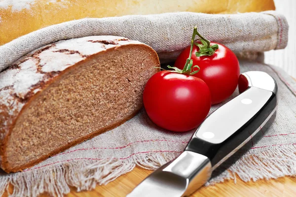 Pão, tomate e faca cortados em fatias de pão, de tomate e de canivete — Fotografia de Stock