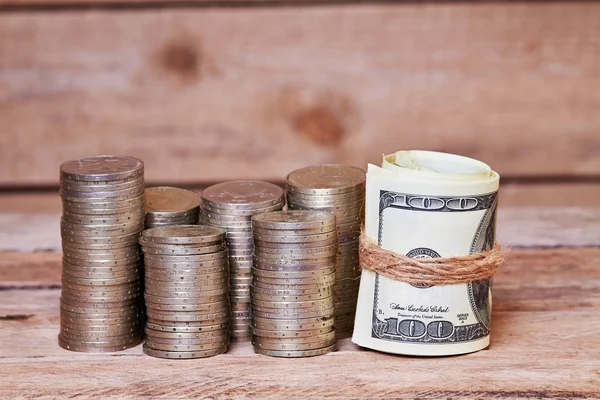 Dollar bills and piles of coins — Stock Photo, Image