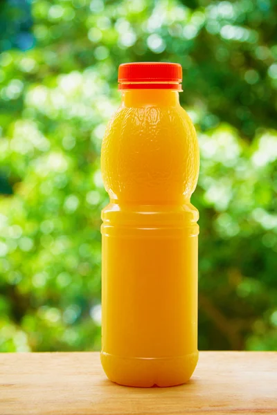 Bottle of orange juice on the wooden table — 图库照片