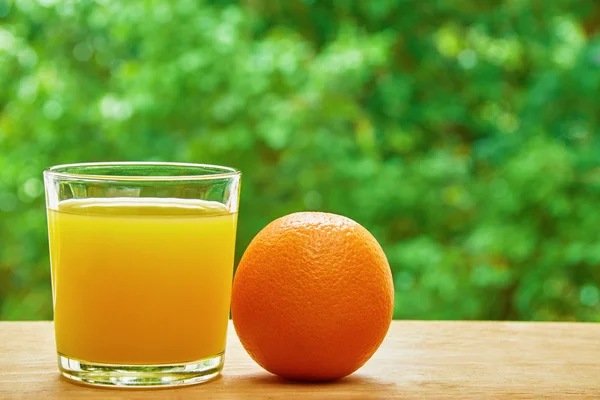 Orange and glass on the table — ストック写真