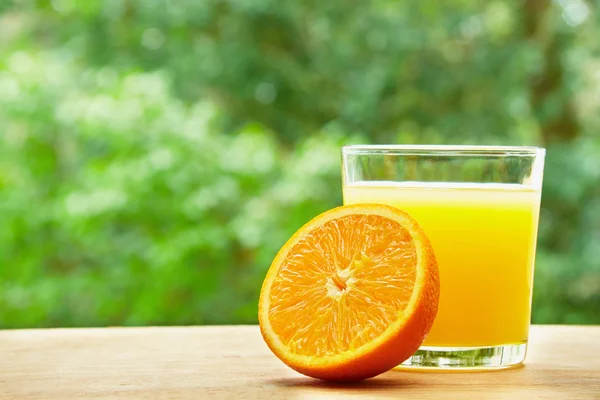 Orange and glass on the table — Stock fotografie