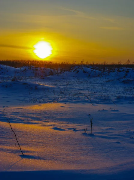 Luz anaranjada del sol de la puesta del sol en la nieve en el campo — Foto de Stock