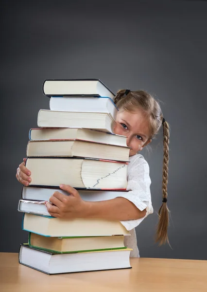 Flickan omfamnar böcker — Stockfoto