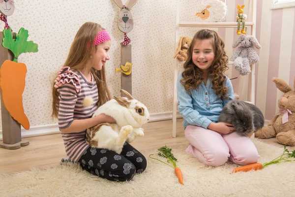 Meninas acariciando os coelhos — Fotografia de Stock