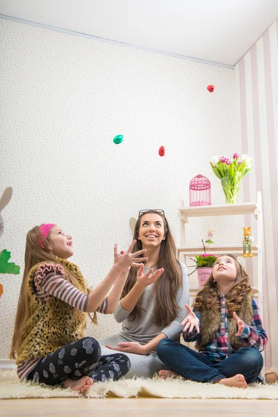 Mother and daughters chocolate eggs thrown — Stock Photo, Image