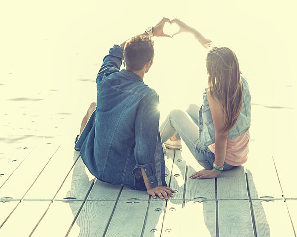 Couple in love sitting on pier