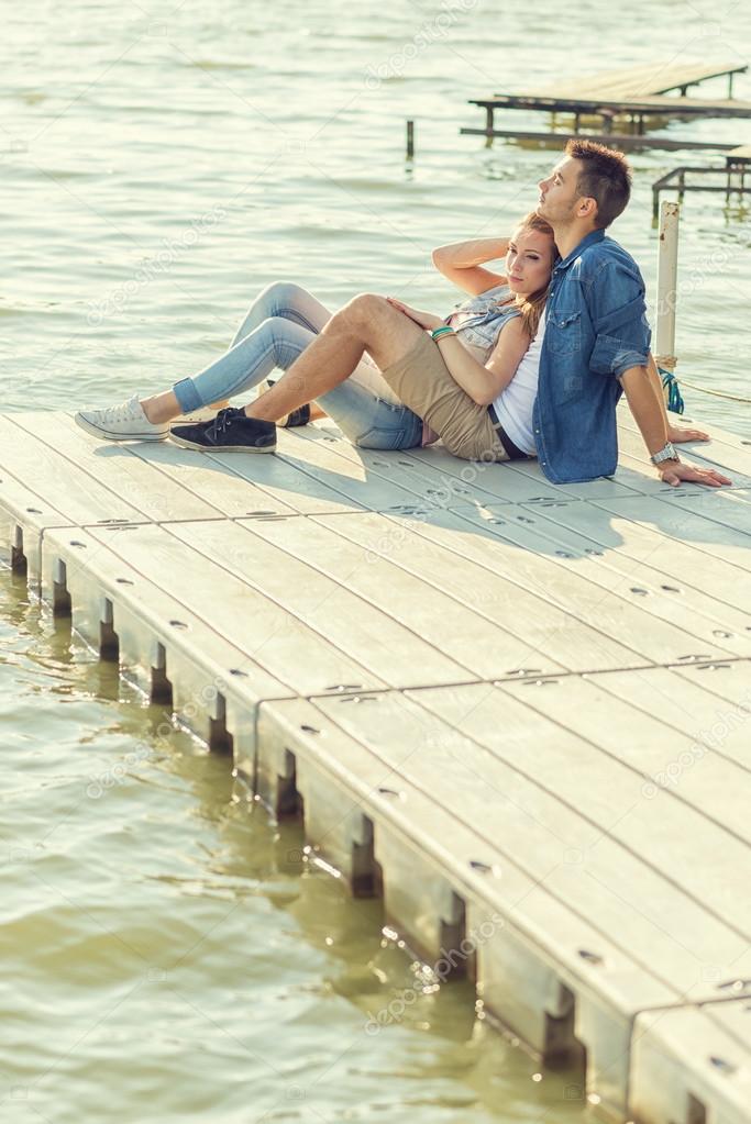 Couple in love sitting on pier