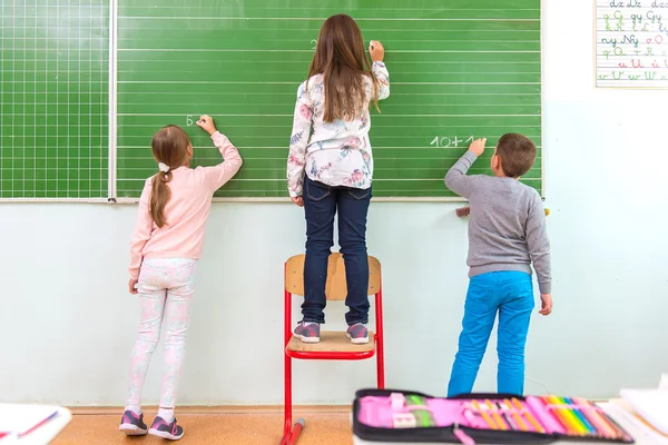 Estudiante escribiendo en pizarra — Foto de Stock