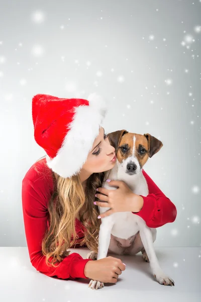 Donna in cappello di Babbo Natale baciare cane — Foto Stock