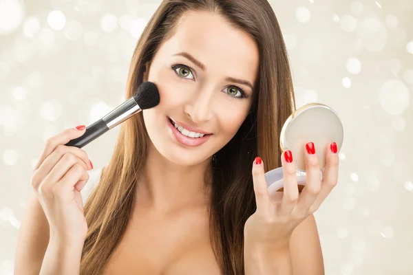 Žena držící zrcadlo a použití make-up — Stock fotografie