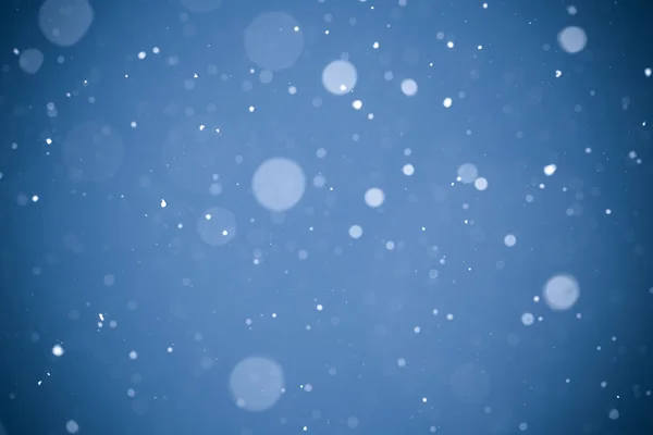 Fallender Schnee auf blauem Hintergrund — Stockfoto