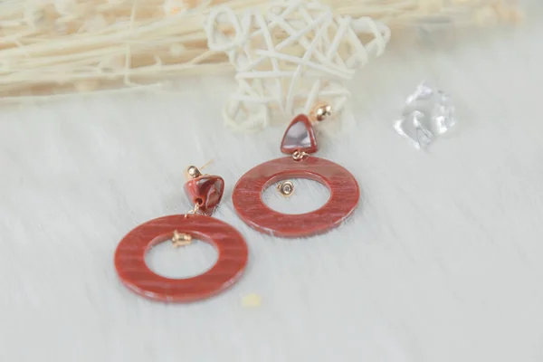 这些耳环是我们自己手工做的 红色耳环也用红色的 耳环上有装饰 是浅色的线条 耳环放在透明的花边纱布上 — 图库照片