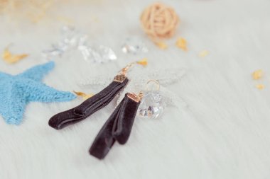 Siyah el yapımı küpeler. Kuru sarı buketler ve rattan ürünlerle eşleştirilmiş. Beyaz yün battaniyenin üzerine koy. Çok şık ve zarif görünüyor..