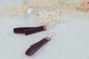 Siyah el yapımı küpeler. Kuru sarı buketler ve rattan ürünlerle eşleştirilmiş. Beyaz yün battaniyenin üzerine koy. Çok şık ve zarif görünüyor..