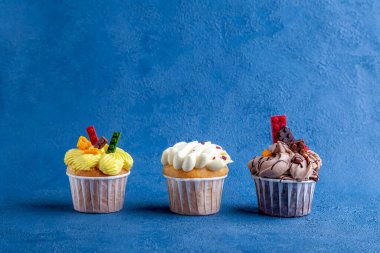 Lezzetli çikolatalı kekler ve eflatun arkaplanlı çilekler.