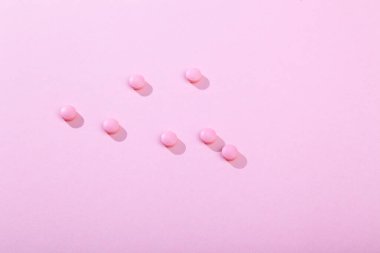 Pembe arka planda haplar, vitaminler ve antibiyotikler, kopyalama alanı