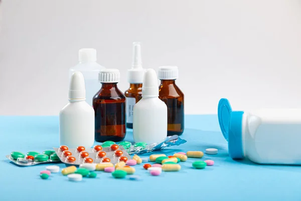 Különböző gyógyszerek, hőmérő, fecskendő, spray, cseppek, szirup, szétszórt színes tabletta, kapszula — Stock Fotó
