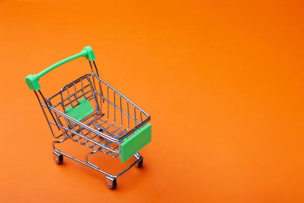 Carro de supermercado vacío de compras en fondo de color — Foto de Stock