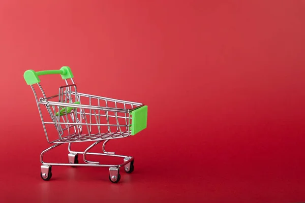 Carro de supermercado vacío de compras en fondo de color — Foto de Stock