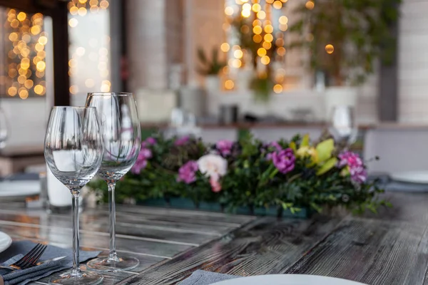 Moderna veranda ristorante interno, fiori, banchetti, bicchieri, piatti — Foto Stock