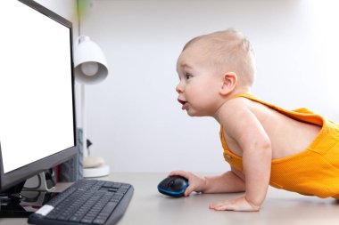 Kafkasyalı komik küçük oğlan bilgisayar, monitör ve klavye keşfediyor.