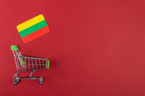 ミニ空のスーパーマーケットショッピングカート,リトアニア,ボリビア赤の背景にフラグ — ストック写真