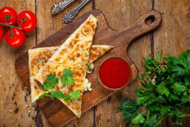 Peynir dolgulu, domates soslu, yeşillikli, geleneksel ev yapımı ekmekli yakın çekim ulusal doğu pastası.