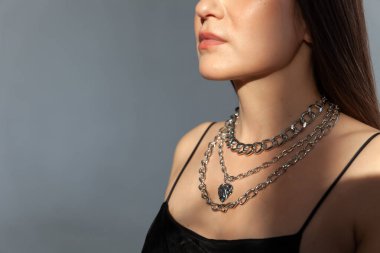 Modern gümüş metal kolyeli güzel bir esmer model, bir sürü zincir.