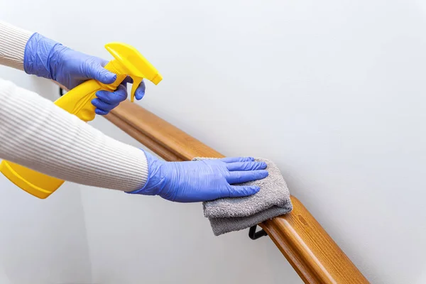 Tangan wanita dalam sarung tangan membersihkan tangga rel dengan kain — Stok Foto