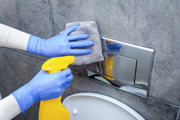 Manos en guantes protectores botón de descarga del inodoro de limpieza — Foto de Stock