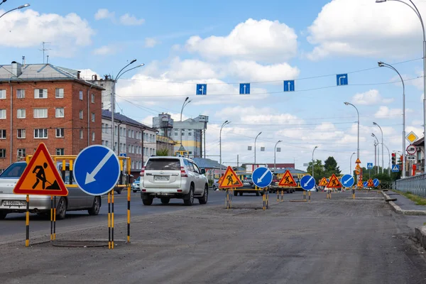 Rússia, Kemerovo 2019-07-11 reparos de estradas de asfalto, sinais de triângulo de aviso amarelo sobre obras rodoviárias e direções de desvio — Fotografia de Stock