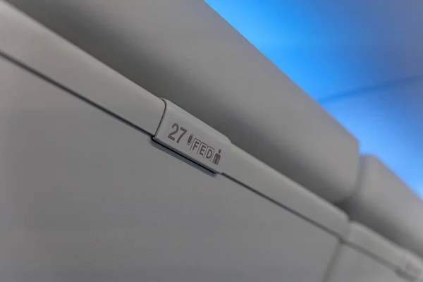 Señal de número de asiento con número y letra en el maletero interior del avión de pasajeros — Foto de Stock