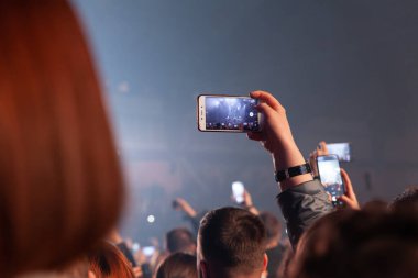 Rusya Kemerovo 2021-04-18 kişi gece parti konserinde akıllı telefondan fotoğraf ve video çekiyor