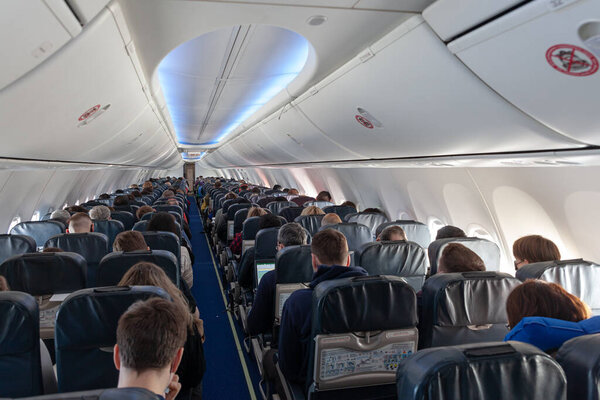 Russia Moscow 2021-03-01 Interior of large airplane with passengers people on seats