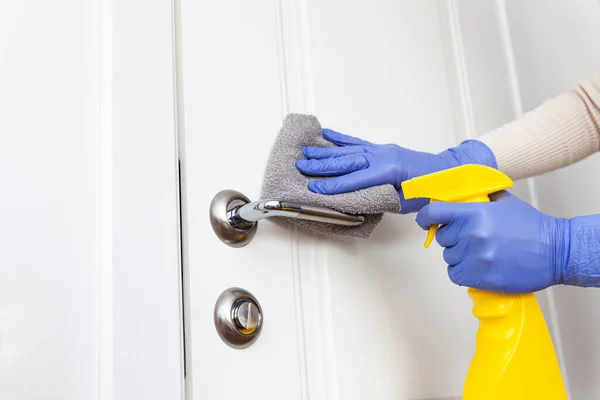 Mani nei guanti disinfettante maniglia della porta con straccio e detergente spray — Foto Stock