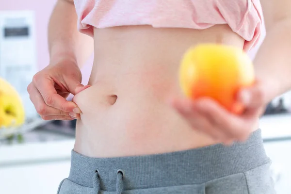 女人把多余的脂肪捏在腰部 增加了额外的脂肪 超重的概念 开始吃健康均衡的清洁食物 — 图库照片