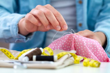 Dikiş işlemi. Ev hanımı evde iğne ve çeşitli dikiş aksesuarları kullanarak elbise ve dikiş diker. 