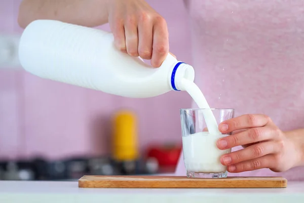 女性はガラスの近くに新鮮な牛乳を注いでいます 乳製品 — ストック写真
