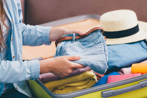 Женщина-путешественница собирает чемодан дома для нового путешествия. Багаж для путешествий в отпуск и приключения
