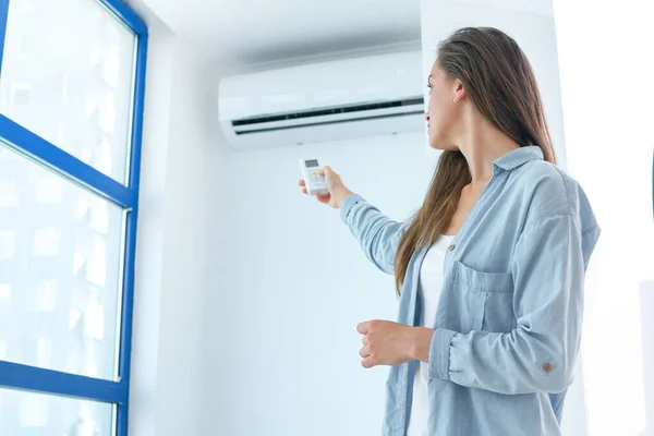 Young Attractive Woman Using Remote Controller Adjustment Air Conditioner Temperature — Stock Photo, Image