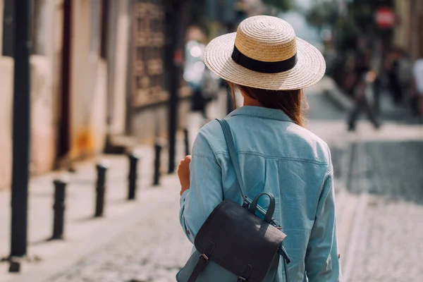 帽子をかぶった旅の女性とヨーロッパの街の通りに沿って歩くバックパック付き 休暇や旅行のライフスタイル 旅行のコンセプト — ストック写真