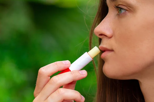 Wanita Menggunakan Lipstik Higienis Untuk Melembabkan Bibir Kering Menutup Pintu — Stok Foto