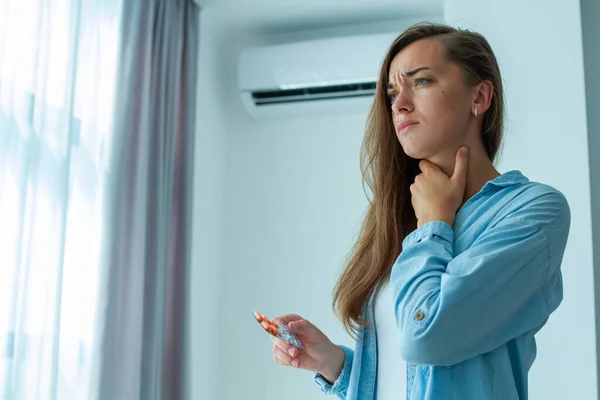 Sad upset woman caught a cold from the air conditioner and suffering from sore throat