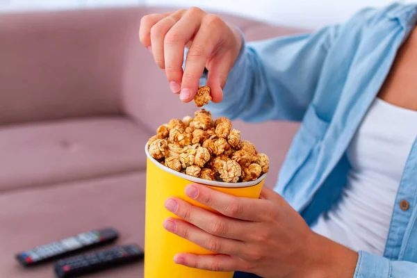 カリカリキャラメルポップコーンボックスのために軽食中にテレビ ホーム — ストック写真