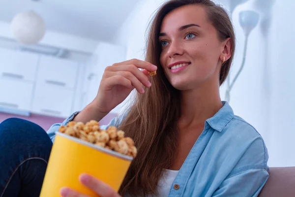 幸せな女性Restingオンソファと食べるカリカリポップコーンの間に見ますテレビ ホーム — ストック写真