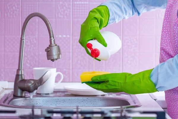 앞치마로 청소하는 스폰지를 사용하고 부엌에서 설거지를 사용하는 세제를 — 스톡 사진