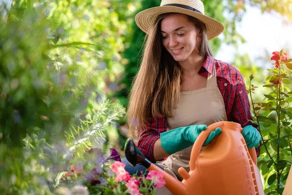 自宅の庭で散水缶と帽子の散水花の幸せな庭師の女性 園芸と花栽培 — ストック写真
