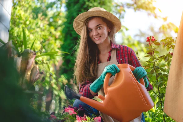 帽子の幸せな笑顔の庭師の女性の肖像画と散水とエプロンは自宅の庭で缶 園芸と花栽培 — ストック写真